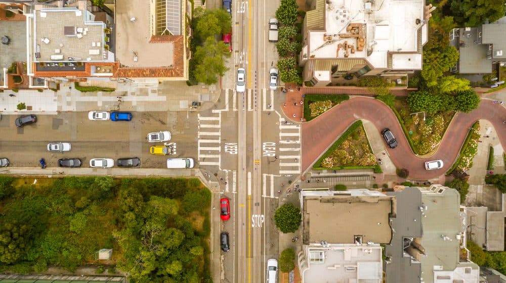 Overhead view of the streets and rooftops of a neighborhood.